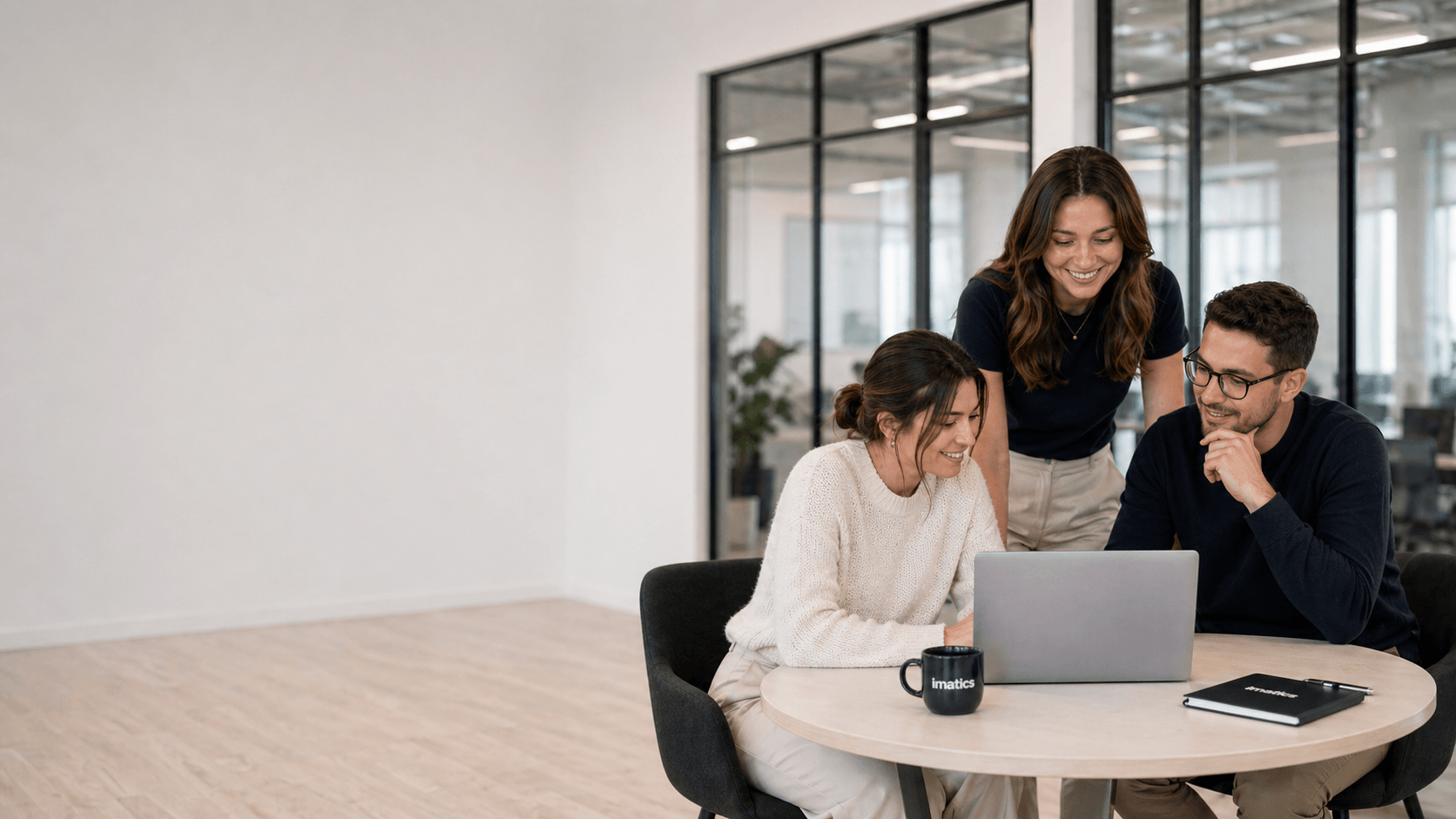 Drei Mitarbeitende besprechen gemeinsam eine IT-Lösung am Laptop